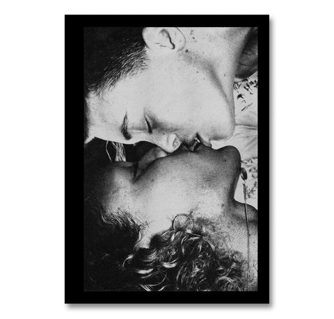 Black and white photograph of two people kissing, framed with a thin black border.