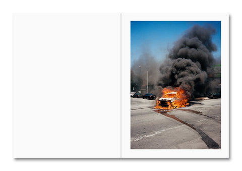 car engulfed in flames in a parking lot